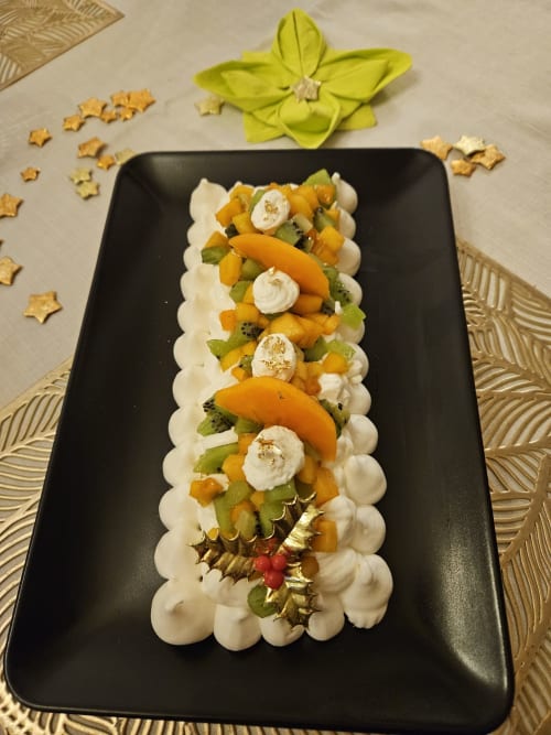 Elegant plated dessert at Aux Prés Du Berry with mango, kiwi, whipped cream and gold leaf