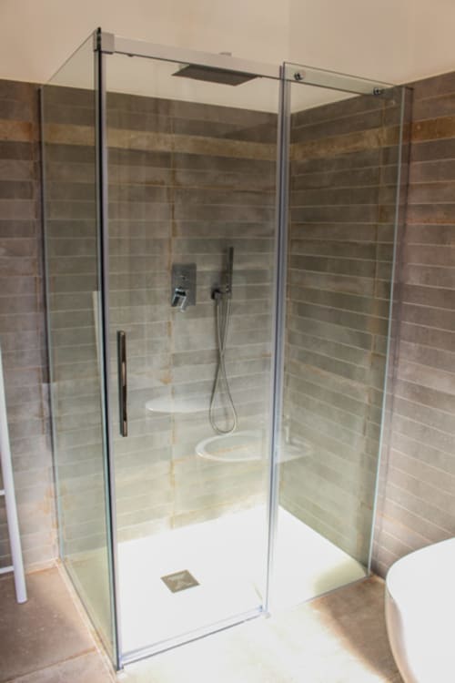 Moderna cabina doccia in vetro con pareti piastrellate e soffione pioggia nella Suite LILA di MAISON TIZI, Fiumicino Roma