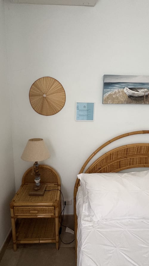 Camera accogliente con mobili in rattan, decorazioni murali intrecciate e arte a tema marino presso Maison Tizi B&B a Fiumicino, Roma