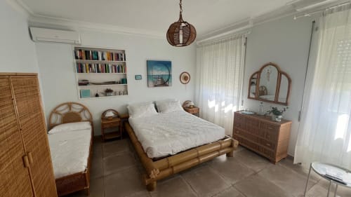 Suite Turchese presso MAISON TIZI con letto in bambù, arredamenti in legno, biancheria bianca, librerie e finestre con vista giardino