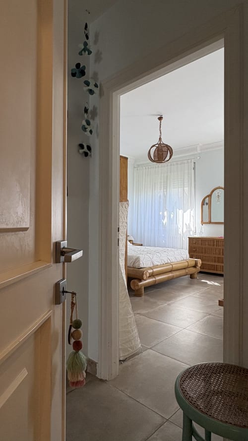 Ingresso della camera Turchese Suite presso MAISON TIZI, Fiumicino Roma—arredamento in bambù, lampada a sospensione intrecciata, vista sul giardino