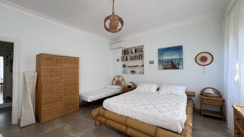 Camera Turchese Suite presso MAISON TIZI con letto matrimoniale, mobili in rattan e vista sul giardino a Fiumicino Roma