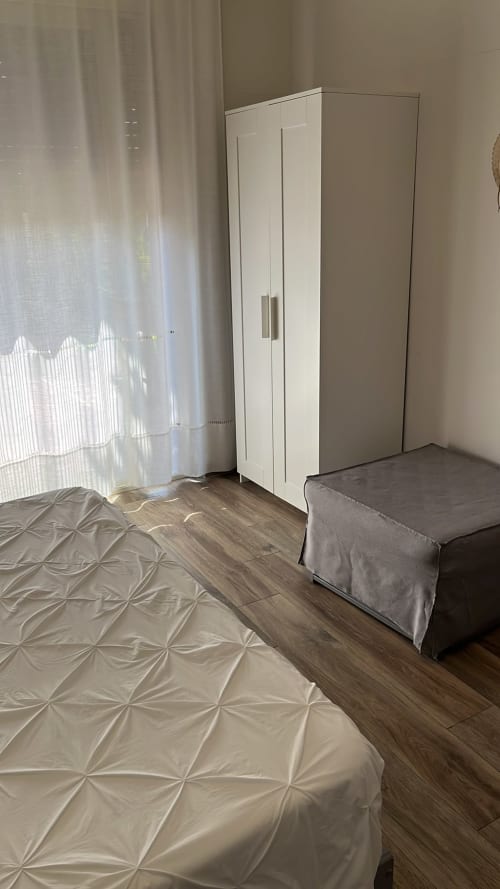 Suite Gardenia luminosa a MAISON TIZI con guardaroba bianco, pavimenti in legno, tende trasparenti e vista giardino