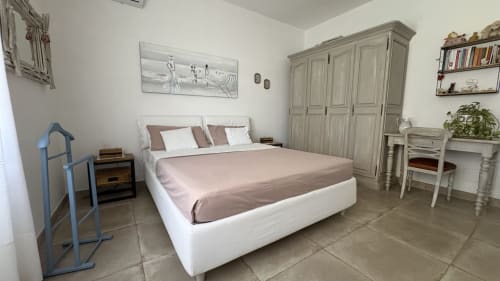 Camera Magnolia Suite MAISON TIZI con letto bianco, armadio grigio, scrivania e vista sul giardino a Fiumicino Roma