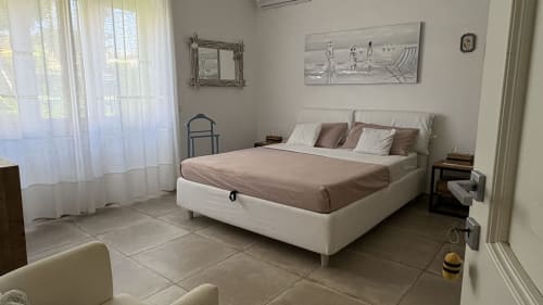 Camera Magnolia Suite presso MAISON TIZI con letto queen, finestre con vista sul giardino, arredamento moderno e aria condizionata