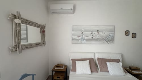 Camera Magnolia Suite presso MAISON TIZI con biancheria bianca, specchio in legno driftwood, arte a tema marino e condizionatore a Roma