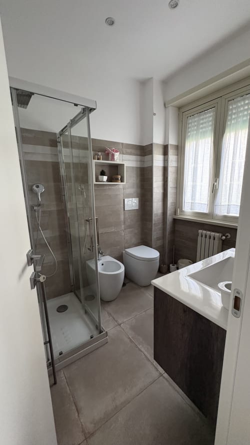 Bagno moderno nella Magnolia Suite di MAISON TIZI con doccia, bidet, wc e lavabo a Fiumicino Roma