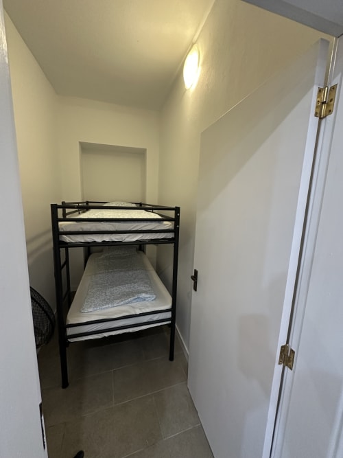 Cama beliche de metal preto com colchões em quarto branco compacto no Villas Simone Porto Santo City & Beach Apartments