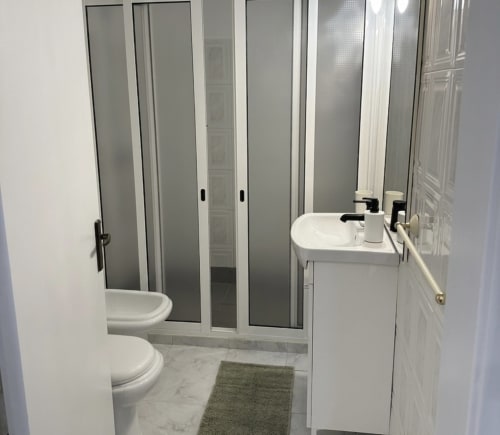 Banheiro moderno no Apartamento Familiar do Villas Simone Porto Santo com cuba branca, sanitário e box de chuveiro.