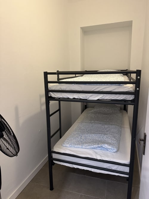 Cama beliche de metal preto com roupa de cama branca no Apartamento Familiar Garden das Villas Simone Porto Santo