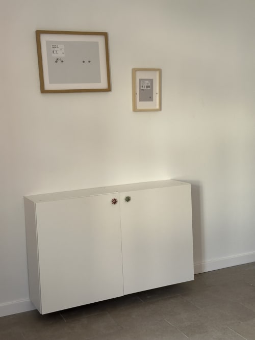 Armário branco com puxadores decorativos e obra de arte emoldurada no quarto do apartamento em Porto Santo