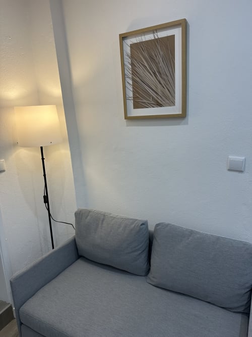 Sofá cinzento com luminária e obra botânica emoldurada no Apartamento Família & Amigos das Villas Simone Porto Santo