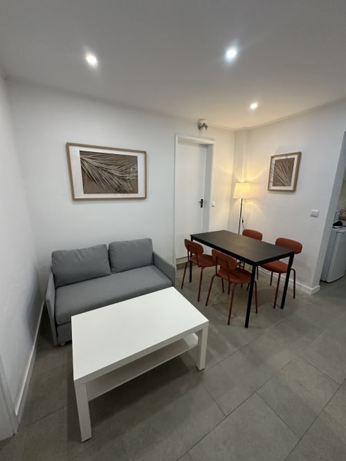 Sala de estar moderna no Villas Simone Porto Santo com sofá cinza, mesa de jantar e cozinha no Apartamento Family & Friends
