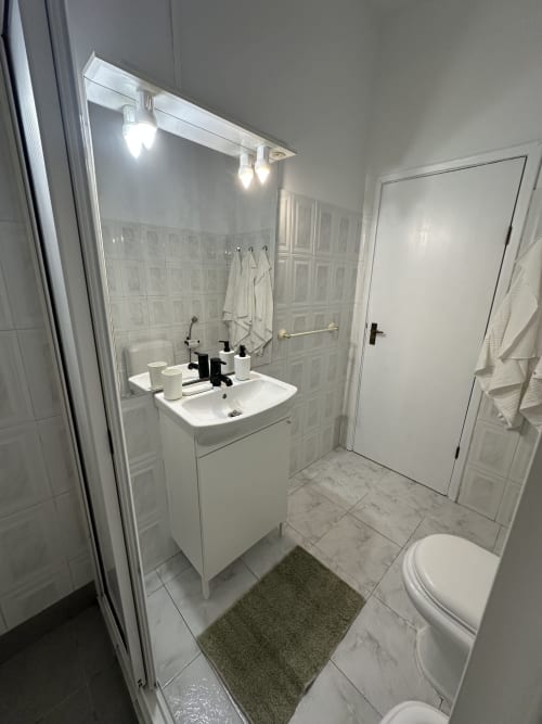 Casa de banho moderna em Villas Simone Porto Santo com pia branca, espelho, sanita e box de duche