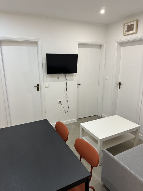 Sala de estar do Apartamento Família & Amigos com TV, mesa de jantar e assentos nas Villas Simone Porto Santo