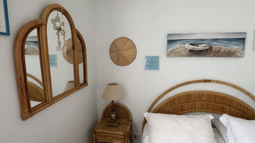 Camera da letto a tema costiero presso Maison Tizi con testata in vimini, specchio in legno e opere d'arte marina a Fiumicino Roma