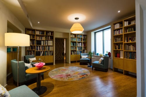 Élégant salon bibliothèque au Domaine de la Peyrine avec rayonnages, sièges confortables et éclairage chaleureux à Carignan de
