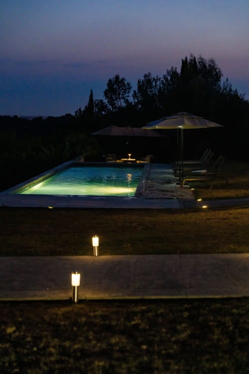 Piscine illuminée au crépuscule, Domaine de la Peyrine à Carignan de Bordeaux, avec parasol et transats