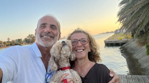 Coppia con piccolo cane sorridenti al tramonto sul lungomare, guest house Maison Tizi Roma