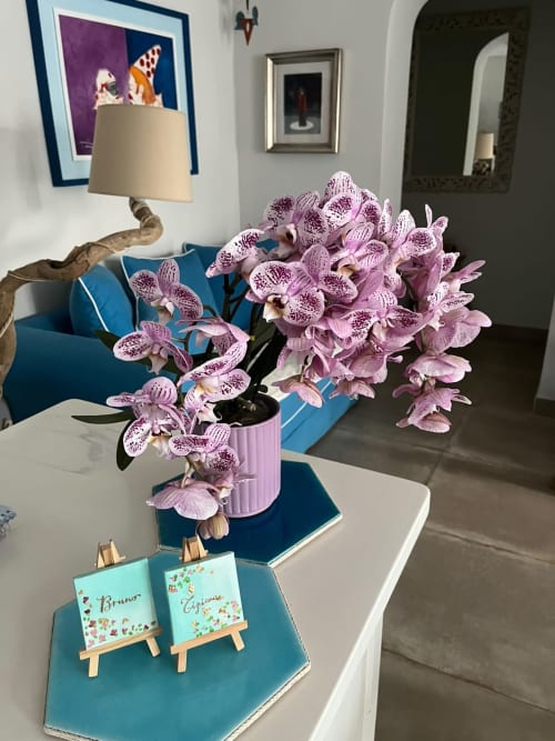 Suite elegante di Maison Tizi con orchidee viola, arredi blu e biglietti nominali personalizzati a Fiumicino, Roma