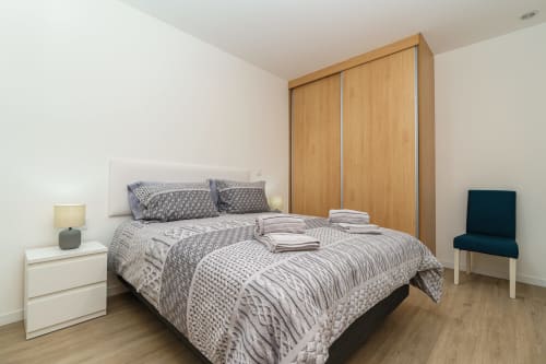 Modern bedroom in Michaels Garden apartment at Garry's Holiday Rentals with queen bed, wooden wardrobe, and garden view in