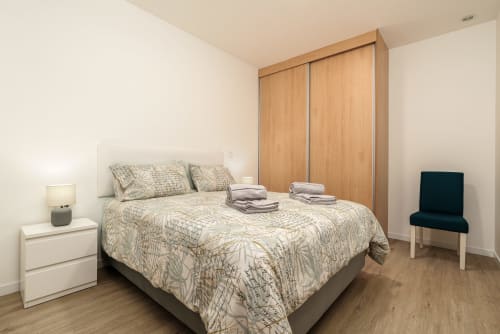 Modern bedroom at Michaels Garden apartment in Estreito da Calheta with wooden wardrobe, bed, nightstand, and garden view