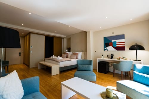 Suite Chickadee au Domaine de la Peyrine : lit, salon bleu, parquets bois et équipements modernes à Carignan-de-Bordeaux