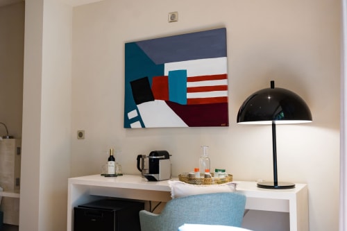 Espace de travail contemporain dans la Suite Chickadee du Domaine de la Peyrine avec lampe noire, station de café et œuvre d'art moderne.
