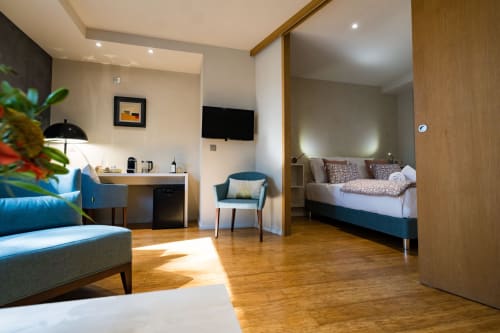 Suite Robin au Domaine de la Peyrine à Carignan de Bordeaux : chambre moderne, salon, kitchenette et boiseries