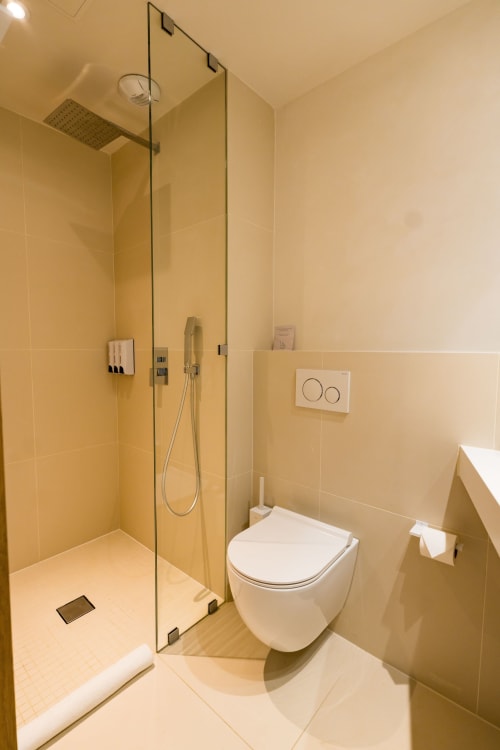 Salle de bains moderne de la Suite Robin au Domaine de la Peyrine, Carignan de Bordeaux, avec douche à l'italienne, toilettes murales et
