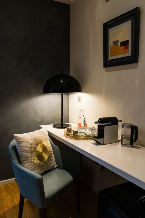 Espace de travail Suite Robin au Domaine de la Peyrine avec chaise bleue, lampadaire noir et coin café avec vue sur le jardin