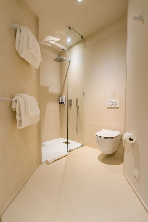 Salle de bain moderne au Domaine de la Peyrine avec douche à l'italienne, toilettes et carrelage crème à Carignan de Bordeaux