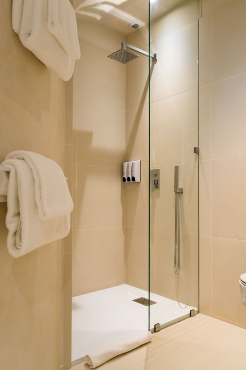 Douche moderne avec portes vitrées et pommeau de douche pluie dans la suite Huppe du Domaine de la Peyrine, Bordeaux