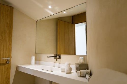 Salle de bain moderne à la Chambre Huppe du Domaine de la Peyrine avec lavabo blanc, grand miroir et accents en bois