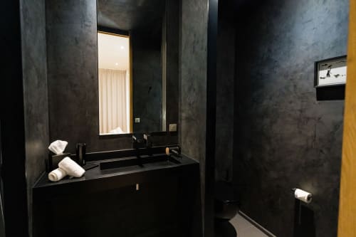 Salle de bain moderne de la Suite Hirondelle au Domaine de la Peyrine avec murs gris foncé, vasque noire, miroir et équipements