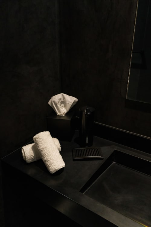 Équipements de salle de bains de la Suite Hirondelle au Domaine de la Peyrine avec serviettes et articles de toilette sur plan de travail sombre