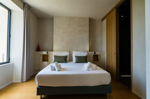 Chambre moderne de la Suite Hirondelle au Domaine de la Peyrine, Carignan de Bordeaux, avec literie blanche et oreillers verts