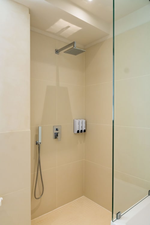 Douche de pluie moderne avec paroi vitrée et murs en carrelage crème à l'hôtel Domaine de la Peyrine à Bordeaux