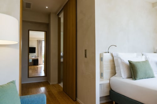 Chambre Pinson au Domaine de la Peyrine avec lit queen-size, accents verts, parquet et entrée couloir