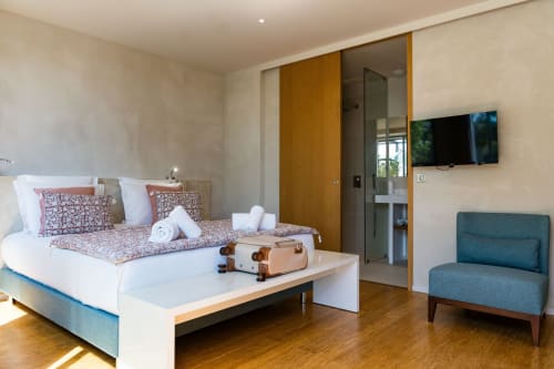 Chambre contemporaine à Domaine de la Peyrine avec lit queen-size, accents bleus-verts, télévision et salle de bains attenante à Carignan de Bordeaux