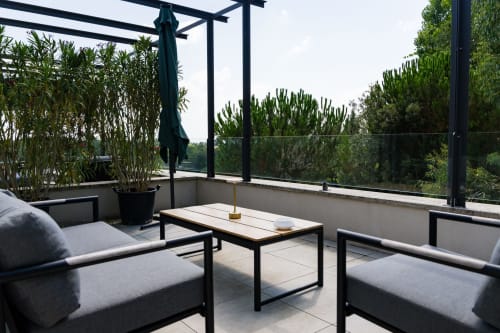 Terrasse moderne au Domaine de la Peyrine avec salon, vue sur l'eau et végétation luxuriante à Carignan de Bordeaux