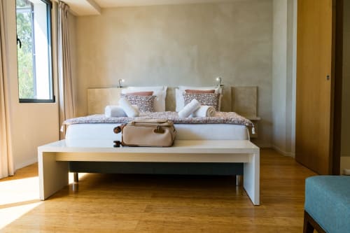 Chambre moderne à l'hôtel Domaine de la Peyrine avec lits jumeaux, banc blanc, parquet et vue sur le jardin
