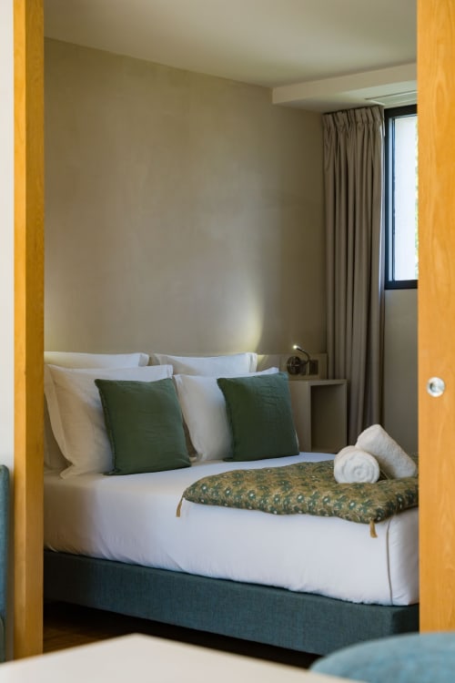 Chambre Tourterelle au Domaine de la Peyrine avec lit queen, coussins verts et vue sur le jardin