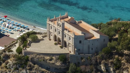 Hotel Mottola Apartments sulla scogliera di Tropea con mare turchese, ombrelloni e architettura mediterranea