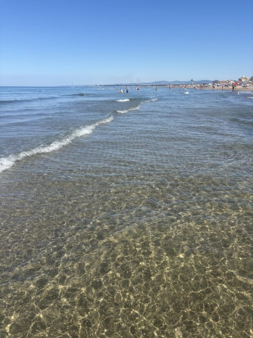 Acque trasparenti e poco profonde con onde dolci alla spiaggia di Passoscuro vicino Roma, ideale per nuotare