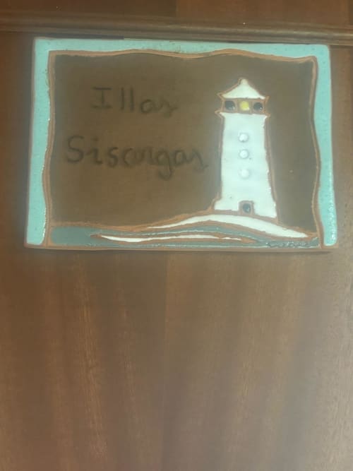 Placa ilustrada con faro en la habitación Sisargas del Hotel O Esqueiro, Malpica, A Coruña
