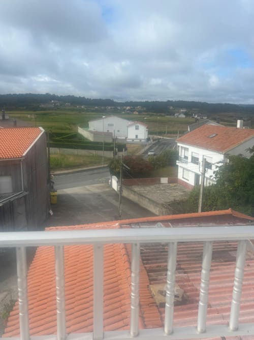 Vista de la terraza de la Habitación Sisargas en Hotel O Esqueiro con vistas al paisaje rural y casas de tejados rojos en Malpica