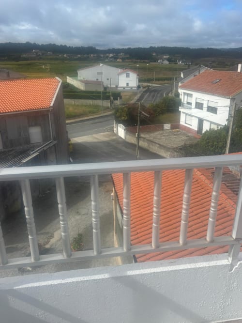 Vista del balcón de la Habitación Sisargas en el Hotel O Esqueiro en Malpica, con vistas al paisaje rural y edificios del pueblo