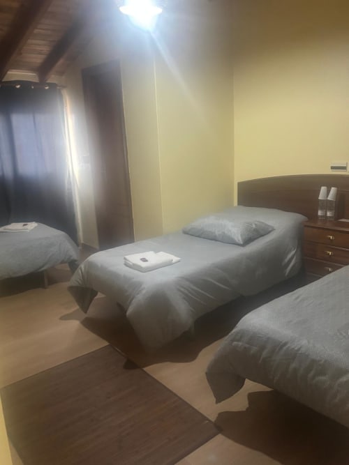 Habitación del Hotel Restaurante O Esqueiro en Malpica con camas gemelas, muebles de madera y paredes amarillas
