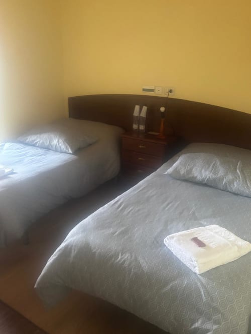 Dos camas individuales con sábanas blancas en la Habitación Sisargas del Hotel Restaurante O Esqueiro, Malpica